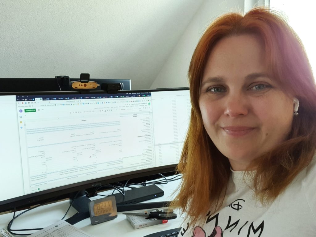 Sandra am Schreibtisch mit einer Excel-Tabelle auf dem Monitor